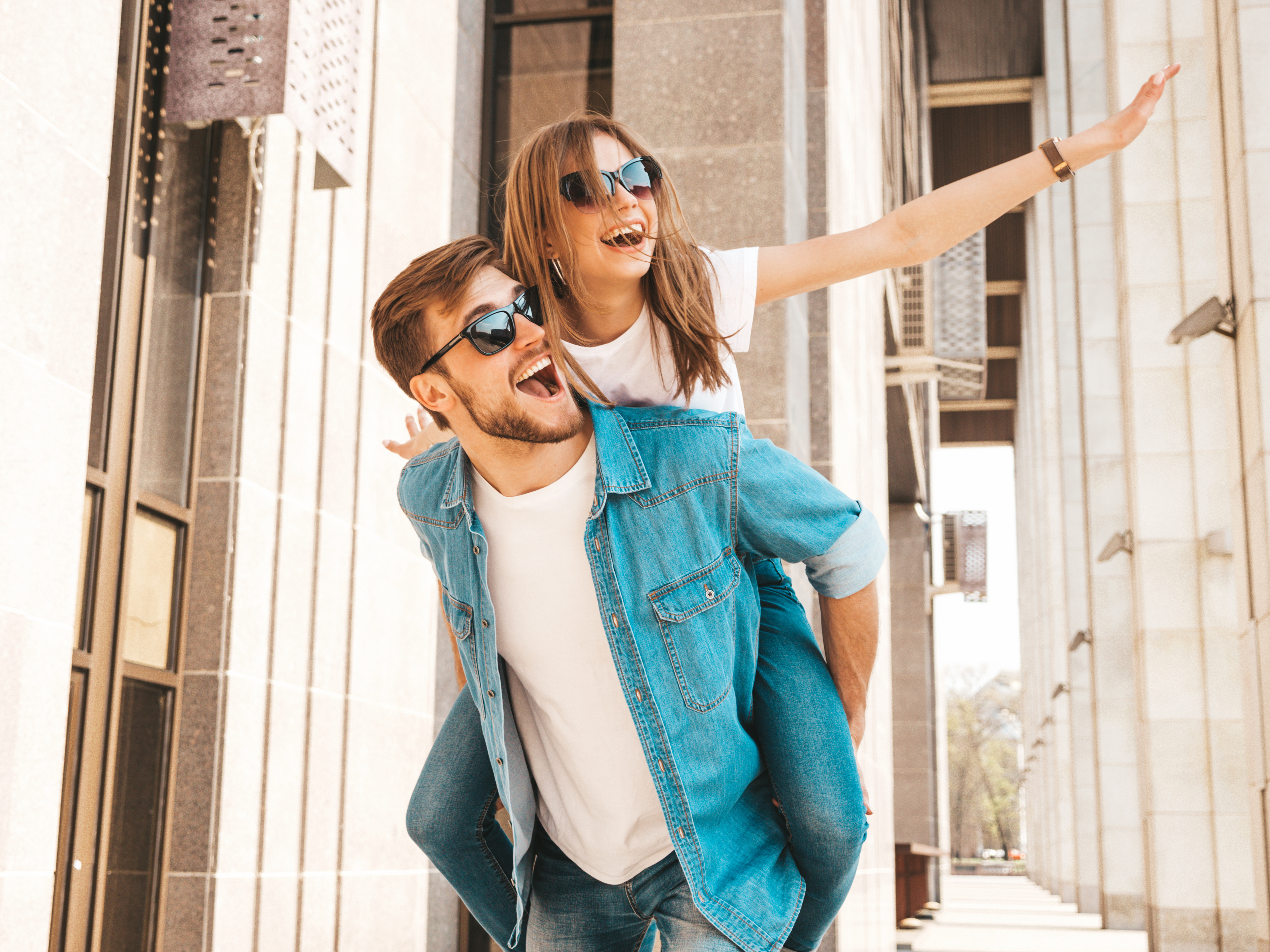 smiling-beautiful-girl-her-handsome-boyfriend-casual-summer-clothes-man-carrying-his-girlfriend-back-she-raising-her-hands (3)